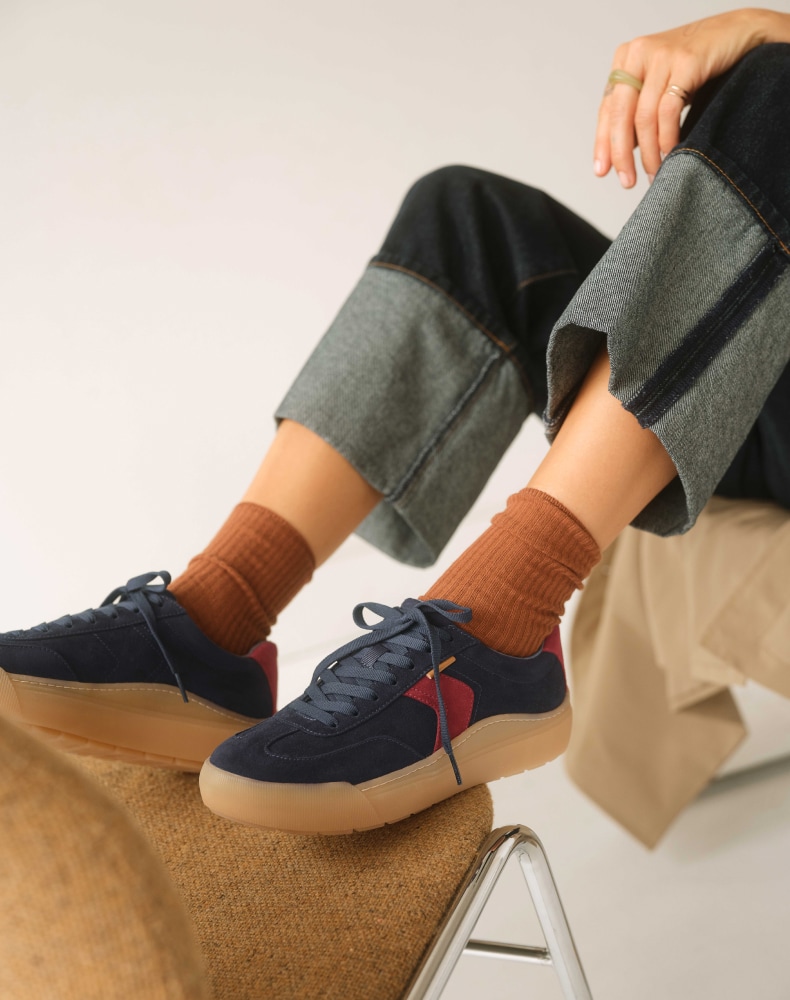 woman relaxing while wearing the time off win sneaker in navy