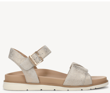 Side view of a women's flat strappy sandal in light gold fabric with an off-white sole. 