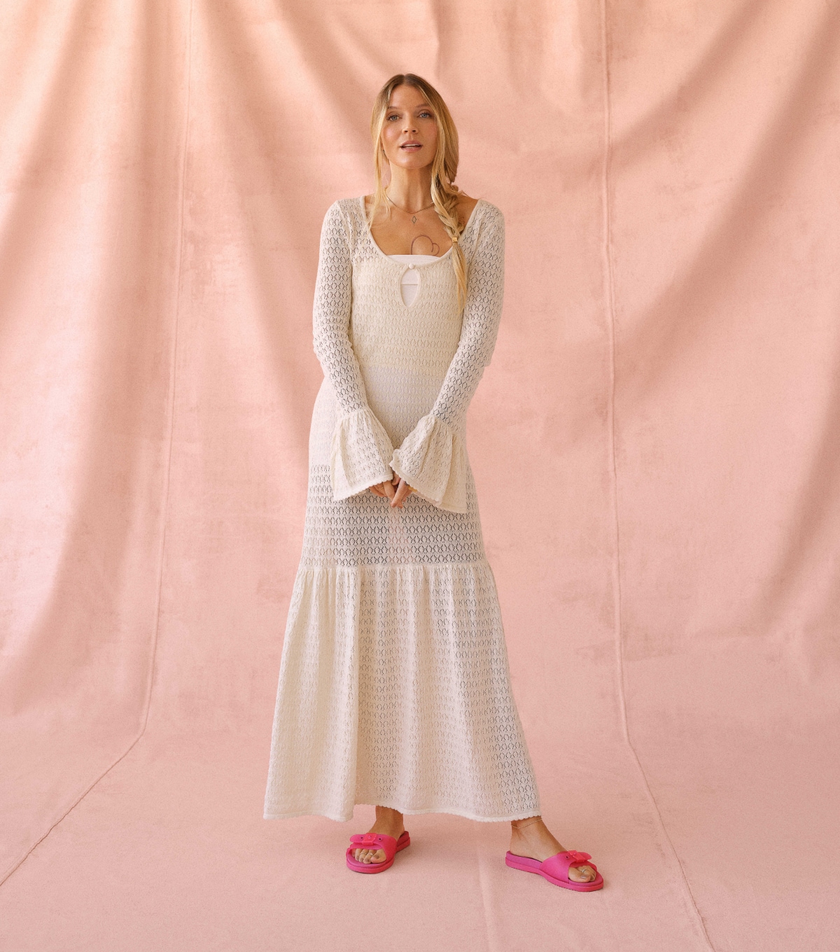 Woman wearing a white, long, bohemian style dress while wearing the So Original Jelly Slide Sandal with feel good foam in daquiri jelly pink