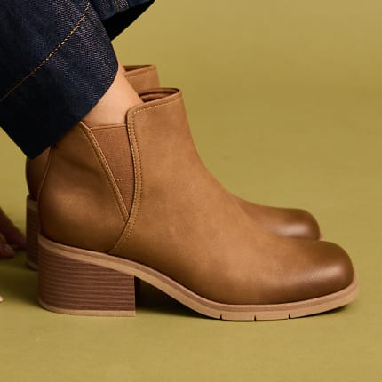 The brown Laurel ankle boots with a block heel being worn with dark denim jeans
