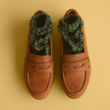 Women's Hello Loafers in honey faux leather with green textured socks inside the shoes.